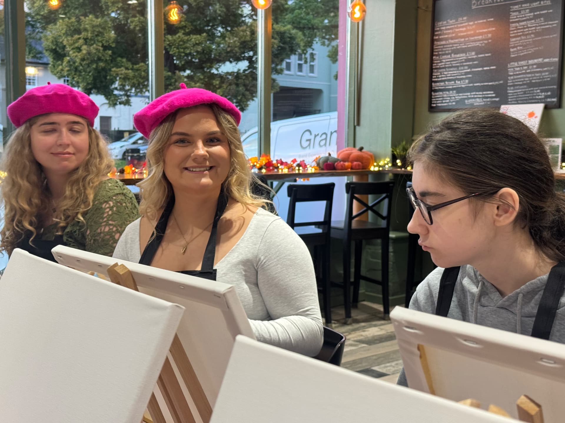 Young women painting at easels during the Newry social group evening.