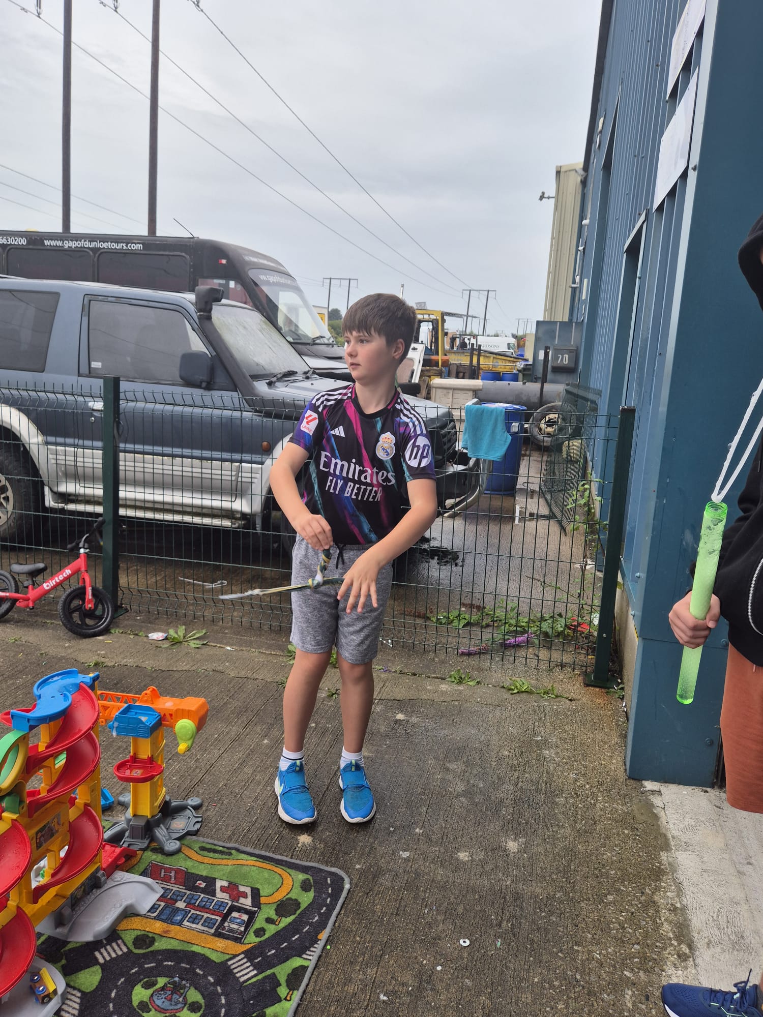 A young man making bubbles with a wand at the ASD Ireland summer camp.