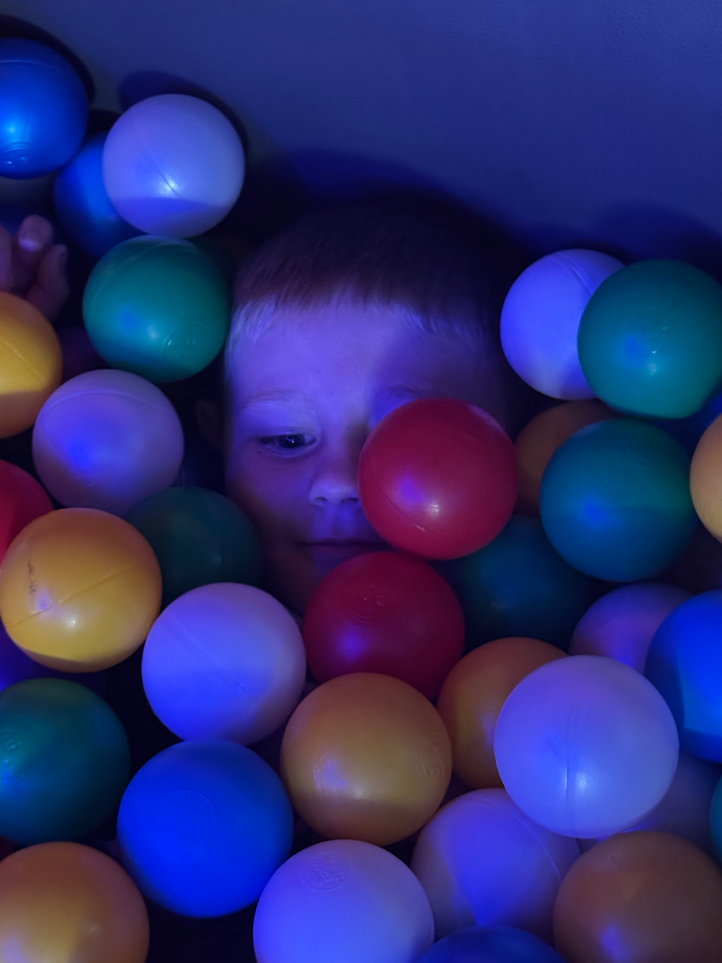 A child among colourful balls inside the mobile sensory room.